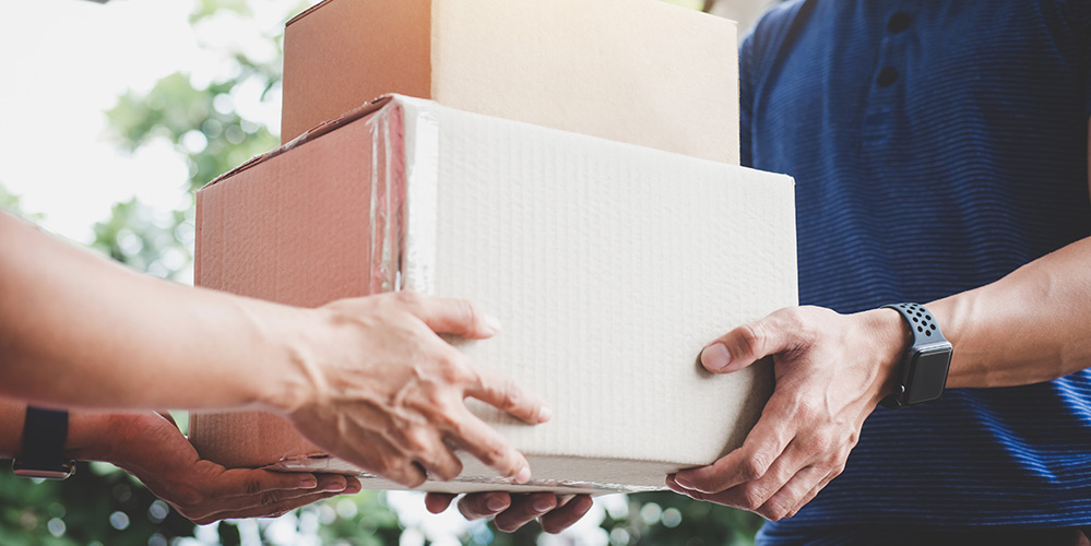 Courier delivering boxes to front door