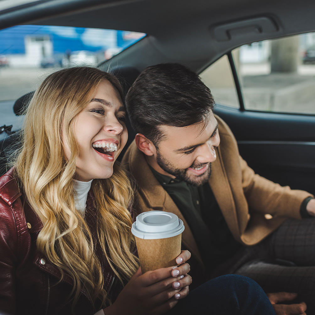 Laughing couple sitting in taxi